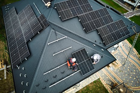 men-workers-installing-solar-panels-on-roof-of-hou-2023-11-27-05-28-29-utc