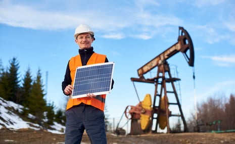 oilman-standing-on-an-oilfield-holding-mini-solar-2023-11-27-05-01-37-utc